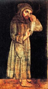 Dipinto di San Francesco d’Assisi in abito francescano marrone, scalzo, con espressione raccolta e gesto di asciugarsi il volto. Lo sfondo scuro accentua la solennità della scena. L’immagine è inserita nell’articolo per rappresentare visivamente la sofferenza fisica del Santo, in particolare la malattia oculare che lo afflisse negli ultimi anni di vita. Il gesto di asciugarsi le lacrime simboleggia sia il dolore umano che la spiritualità profonda, rafforzando il tema dell’articolo sulla cecità e la resilienza mistica di Francesco.